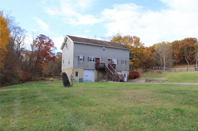 a view of a house with a big yard and a large tree