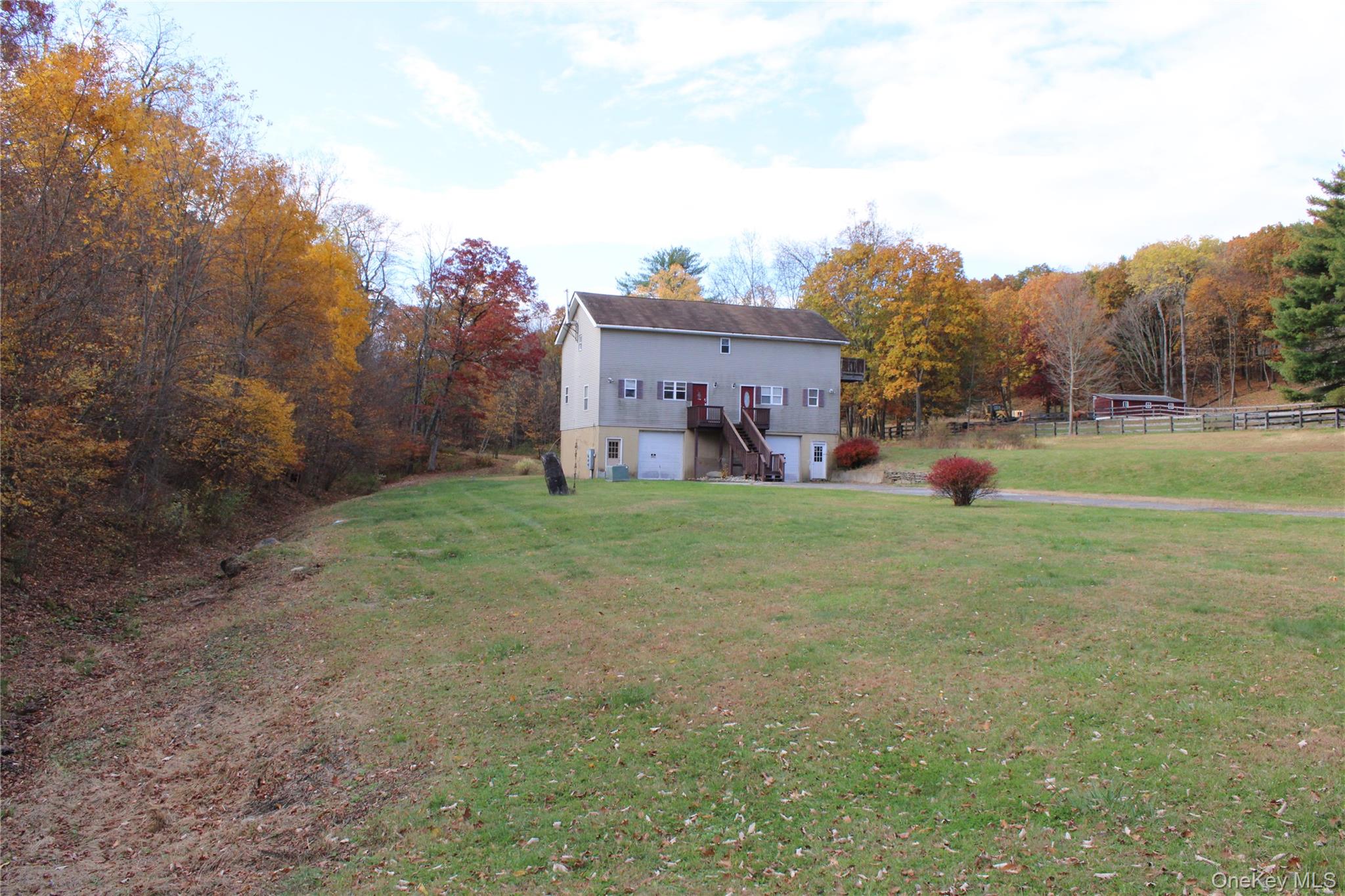 400 Round Lake Road Rhinebeck, NY 12572 - Photo 20 of 34 Rear view of property with stairs, a garage, stucco siding, and a forest view