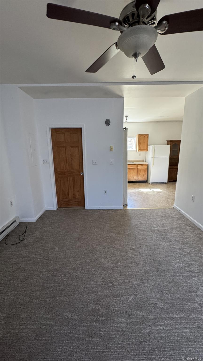 400 Round Lake Road Rhinebeck, NY 12572 - Photo 30 of 34 Unfurnished living room featuring carpet, baseboard heating, and ceiling fan