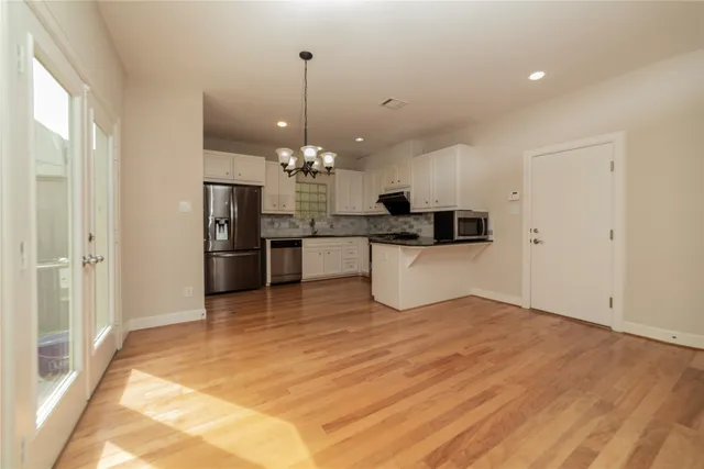 a view of a kitchen with a sink wooden floor and a chandelier