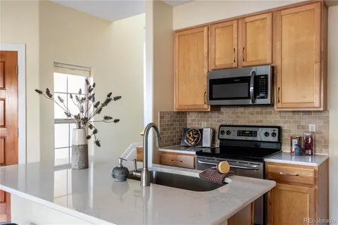 a kitchen with stainless steel appliances granite countertop a sink a stove and a microwave