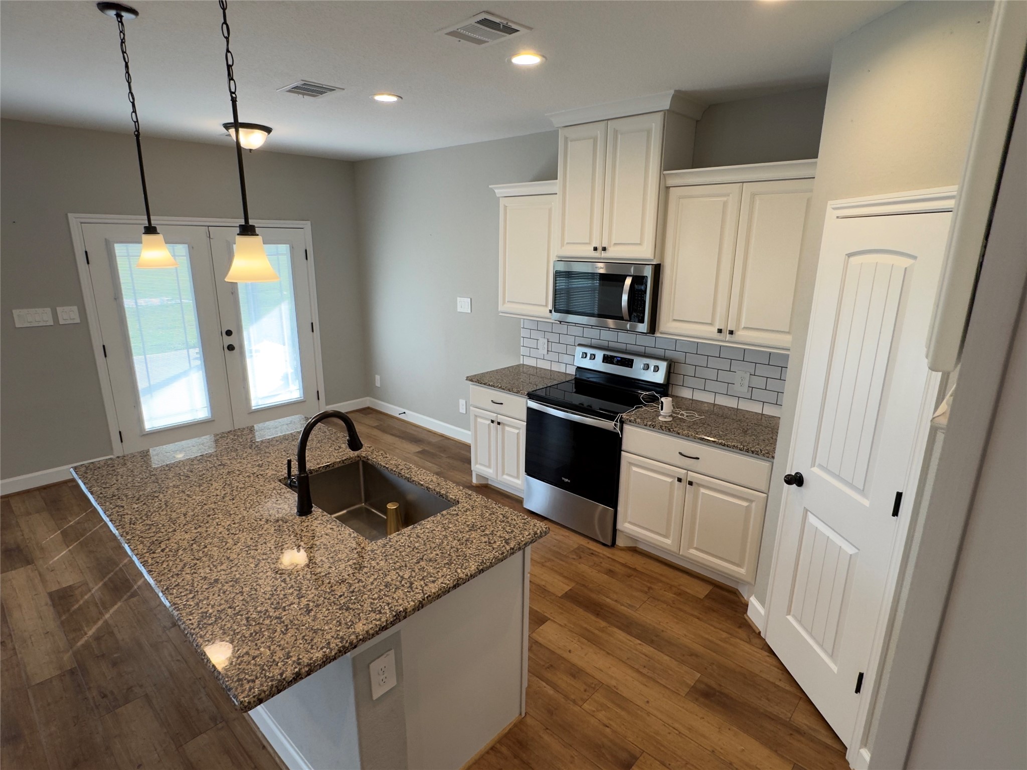 723 Sandy Corner Road El Campo, TX 77437 - Photo 6 of 20 Stunning kitchen with granite countertops, stainless steel appliances, and elegant pendant lighting. All perfect for culinary enthusiasts.