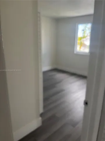 an empty room with wooden floor and cabinet