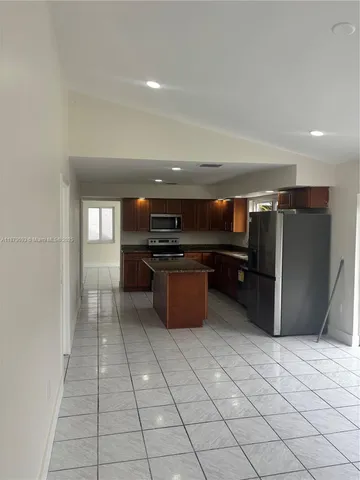 a kitchen with stainless steel appliances granite countertop a refrigerator and a sink