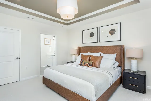 a bedroom with a bed and a lamp on dresser