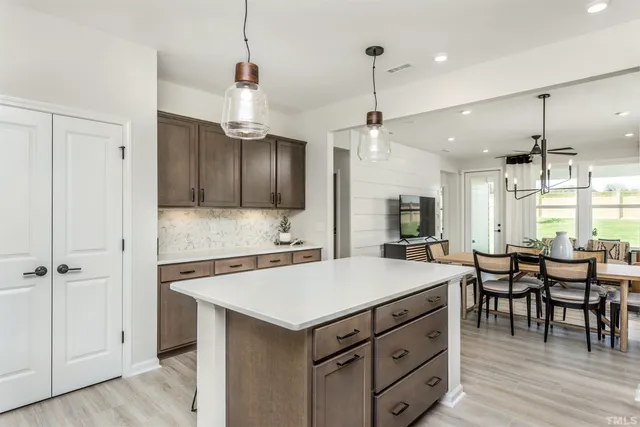 a kitchen with a stove a refrigerator and wooden cabinets