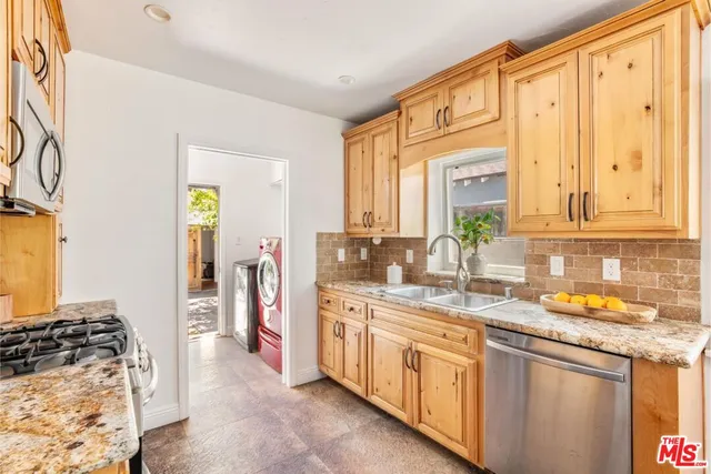 a kitchen with stainless steel appliances granite countertop a stove and a sink