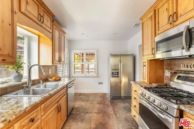 a kitchen with stainless steel appliances granite countertop a sink stove and refrigerator