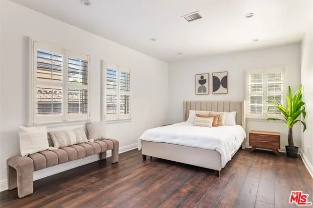 a bedroom with a bed couch and a large window