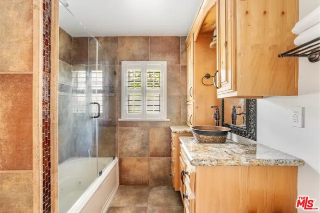 a bathroom with a granite countertop sink and a bathtub