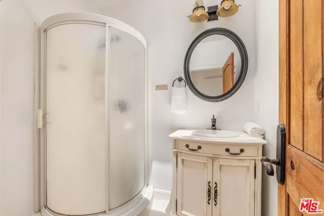 a bathroom with a sink a mirror and a shower