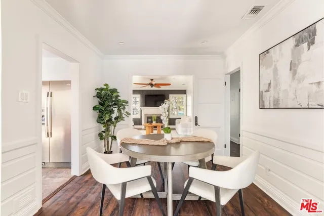 a dining room with furniture potted plants and wooden floor
