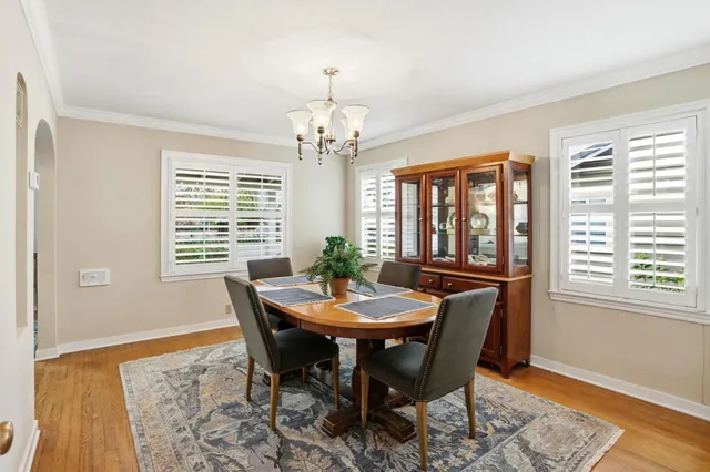 a view of a dining room with furniture wooden floor and a chandelier