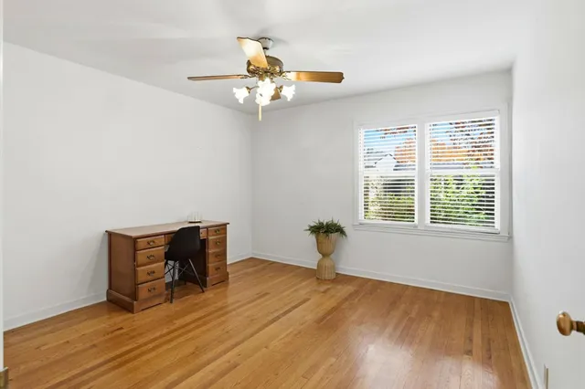 a view of an empty room with a window and wooden floor