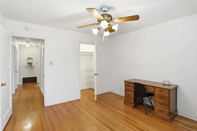 a view of a room with wooden floor table and chairs
