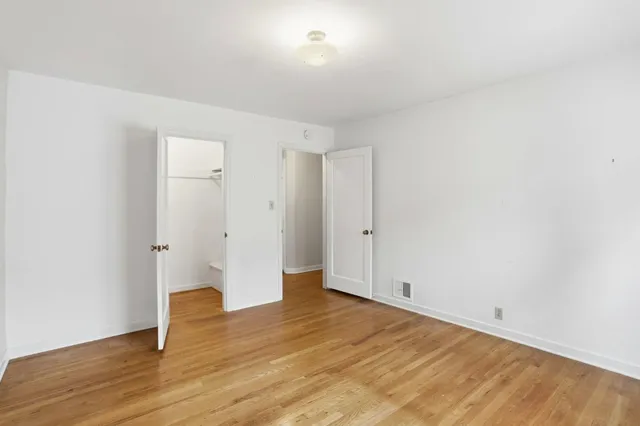 a view of an empty room with wooden floor
