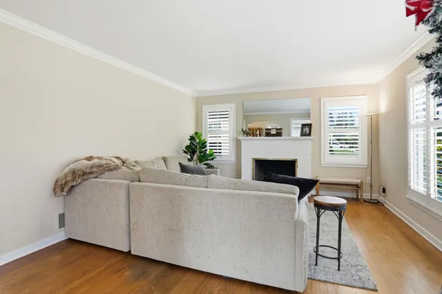 a living room with furniture a fireplace and a large window