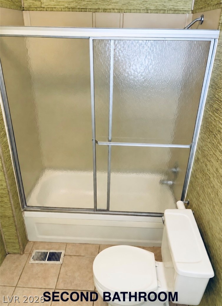 4556 Royal Ridge Way Las Vegas, NV 89103 - Photo 23 of 49 A classic bathtub and shower combination sits adjacent to the tiled floor.