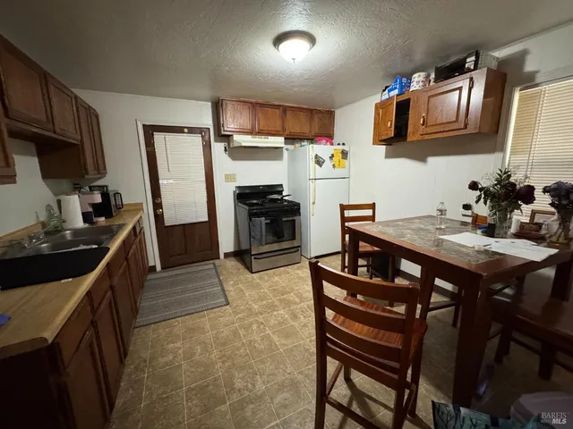 a kitchen with stainless steel appliances granite countertop a stove refrigerator sink and microwave