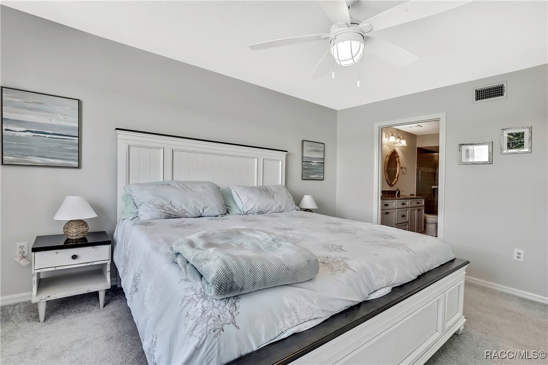 2855 North Rivers Edge Boulevard, Unit 213 Crystal River, FL 34429 - Photo 23 of 62 a bedroom with a bed and a chandelier