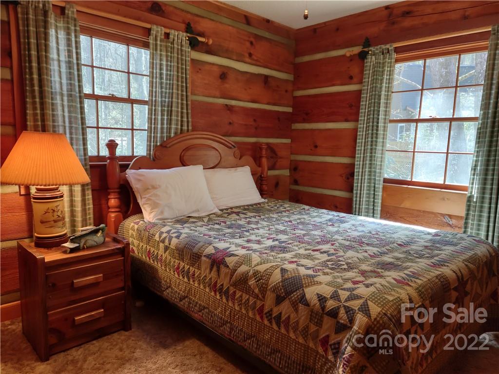 233 Nottingham Road Maggie Valley, NC 28751 - Photo 23 of 44 a bedroom with a bed and a dresser next to a window