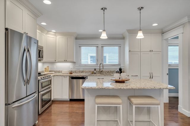 a kitchen with granite countertop stainless steel appliances a sink stove and refrigerator