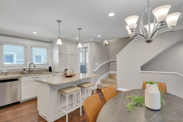 a kitchen with stainless steel appliances granite countertop a sink a stove and a wooden floor