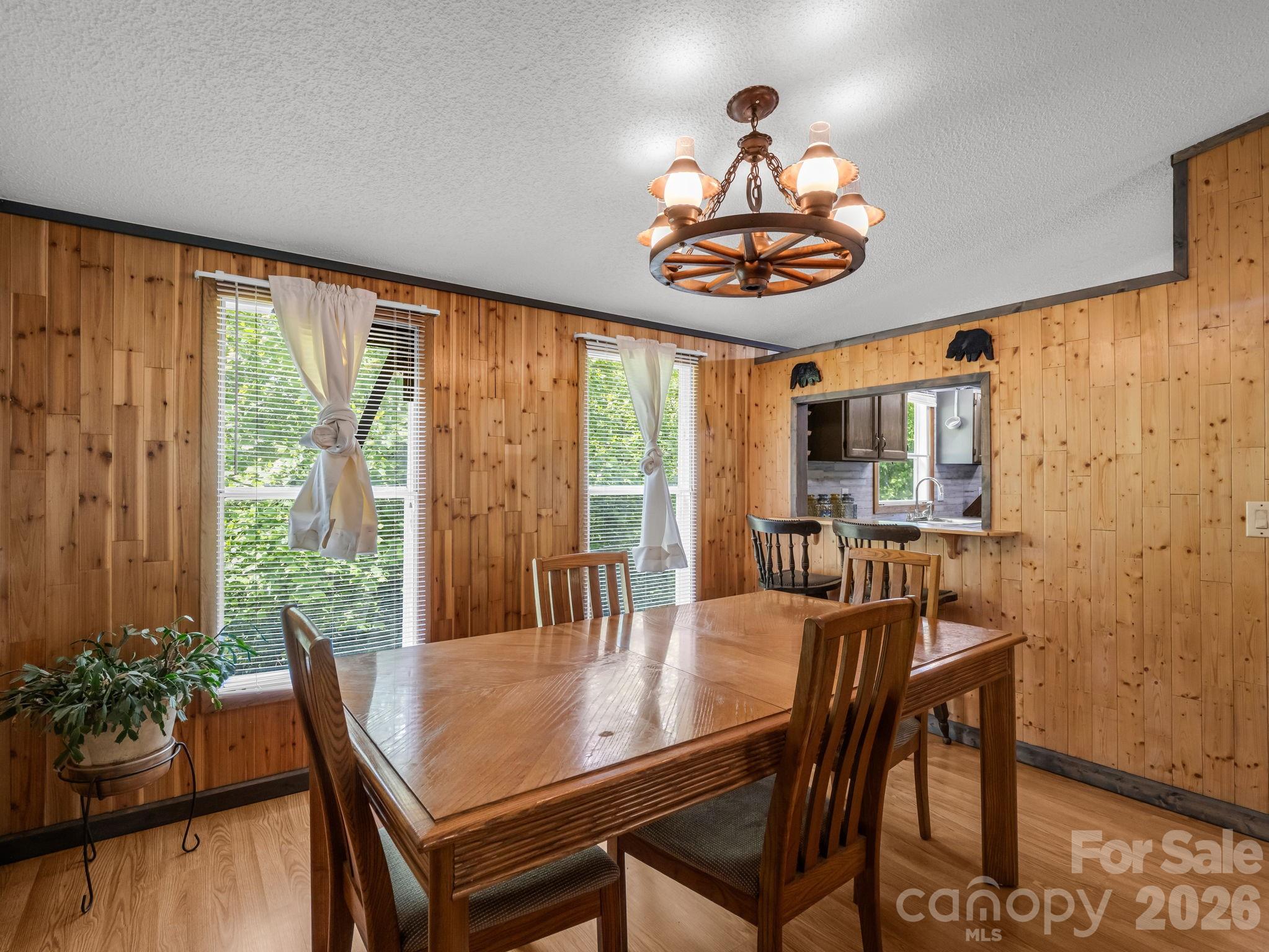 2053 Nancy Mountain Road Rosman, NC 28772 - Photo 15 of 47 a dining room with wooden floor a chandelier a wooden table and chairs