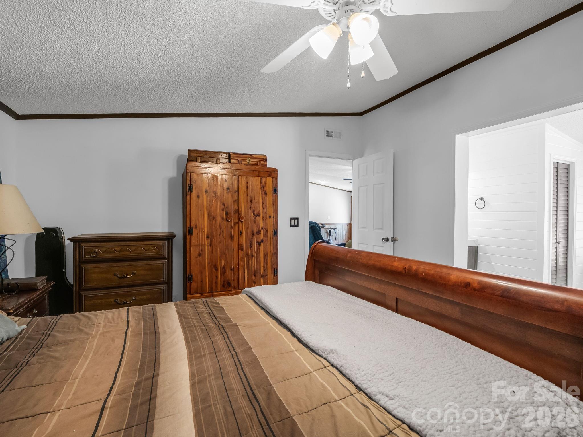 2053 Nancy Mountain Road Rosman, NC 28772 - Photo 25 of 47 a bedroom with a bed and a chandelier