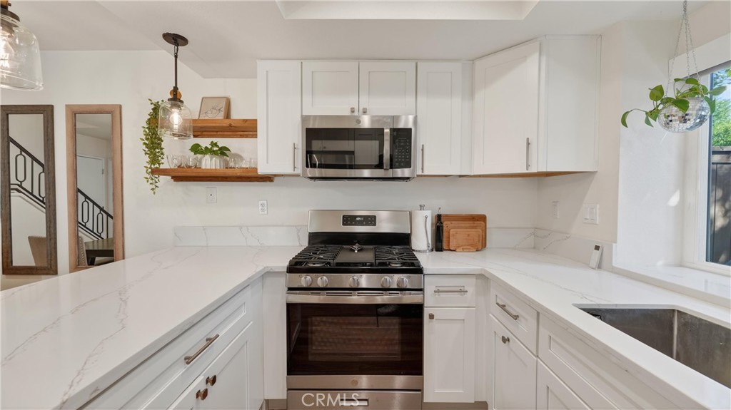 1761 Forum Way, Unit D Corona, CA 92881 - Photo 13 of 39 a kitchen with stainless steel appliances granite countertop white cabinets a stove a sink and dishwasher