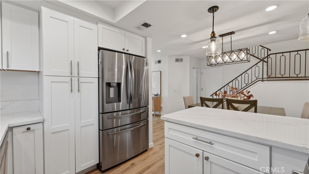 1761 Forum Way, Unit D Corona, CA 92881 - Photo 14 of 39 a kitchen with stainless steel appliances kitchen island a refrigerator and cabinets