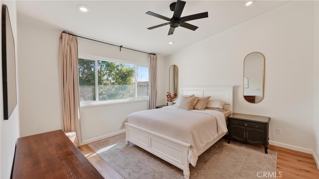 1761 Forum Way, Unit D Corona, CA 92881 - Photo 19 of 39 a bedroom with a bed a ceiling fan and a large window
