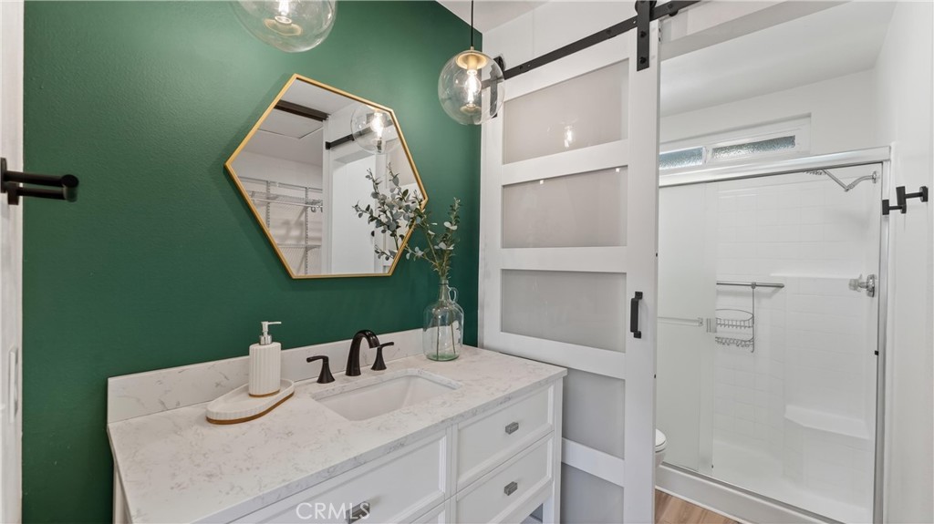 1761 Forum Way, Unit D Corona, CA 92881 - Photo 22 of 39 a bathroom with a granite countertop sink a mirror and shower