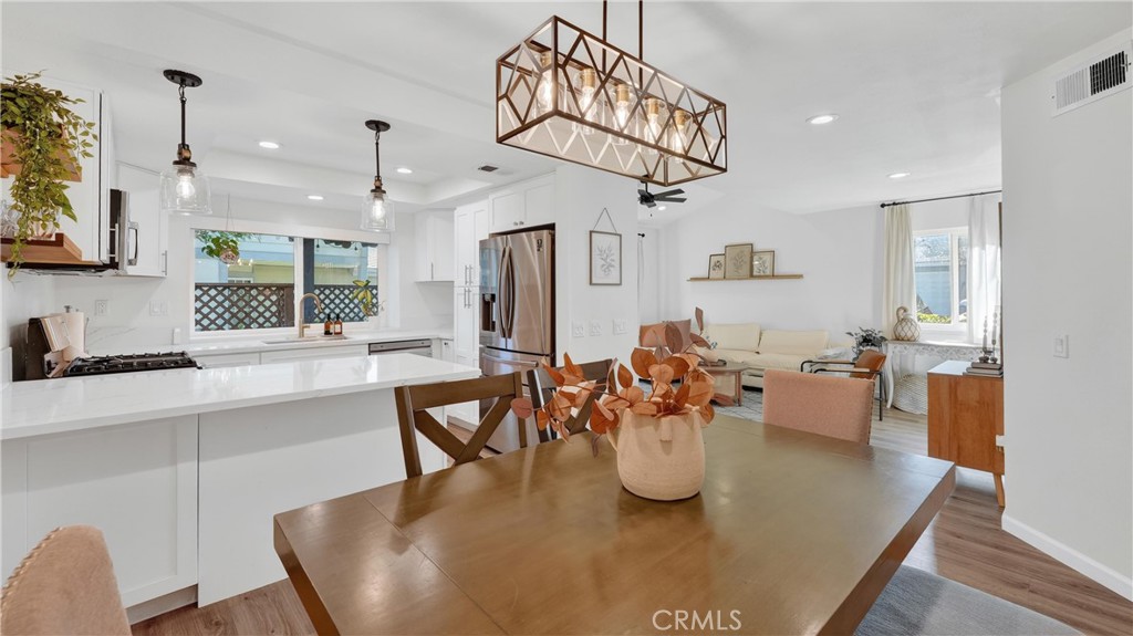 1761 Forum Way, Unit D Corona, CA 92881 - Photo 7 of 39 a dining room with wooden floor a chandelier a wooden table and chairs