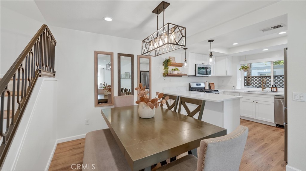 1761 Forum Way, Unit D Corona, CA 92881 - Photo 8 of 39 a kitchen with stainless steel appliances granite countertop a sink a stove a dining table and chairs