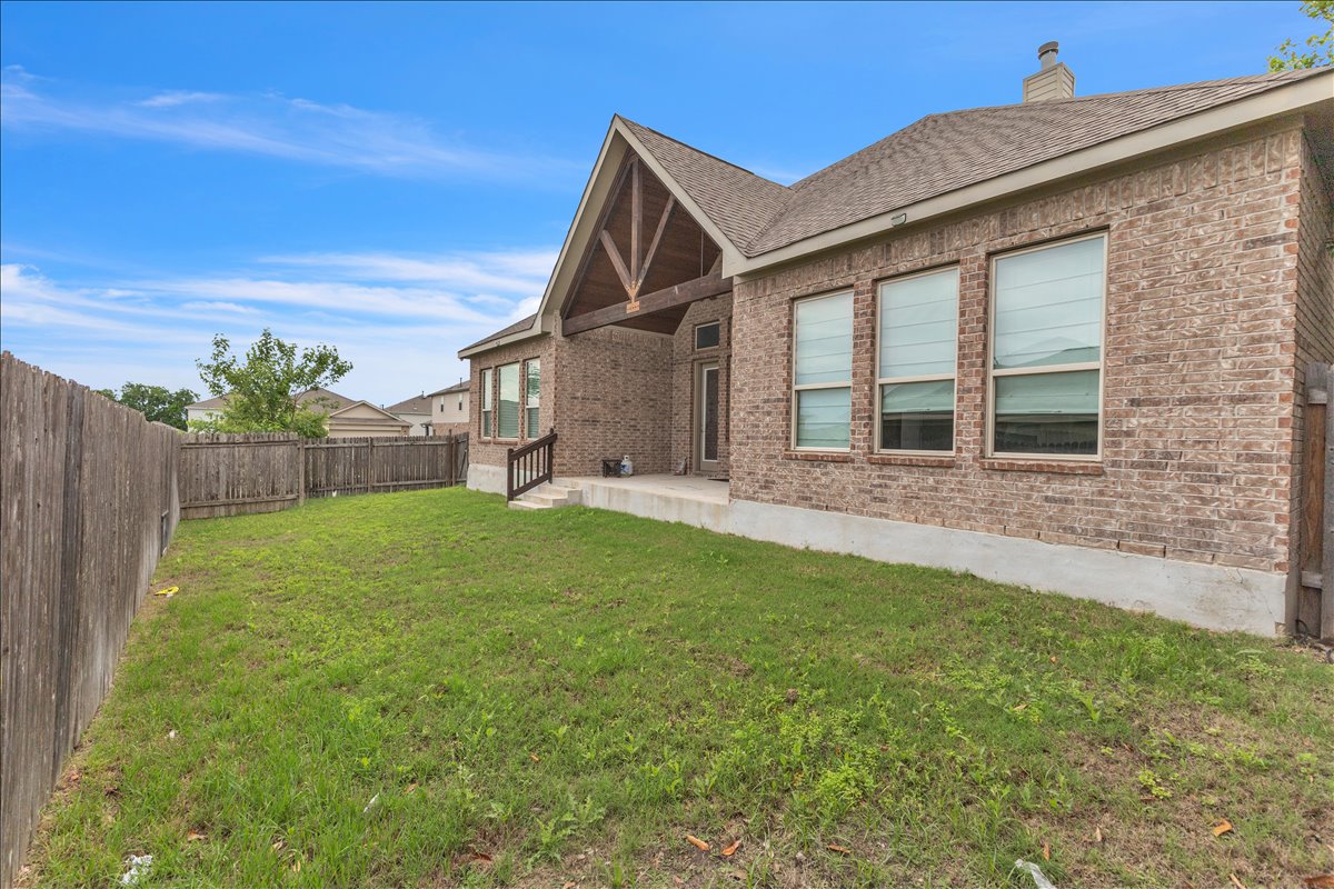 21301 Resource Road Pflugerville, TX 78660 - Photo 22 of 29 Fenced backyard featuring a covered patio with exposed wood beams, brick exterior, and multiple windows