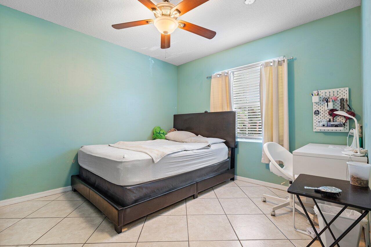 177 Heming Way Boynton Beach, FL 33426 - Photo 13 of 22 a bedroom with a bed and a desk