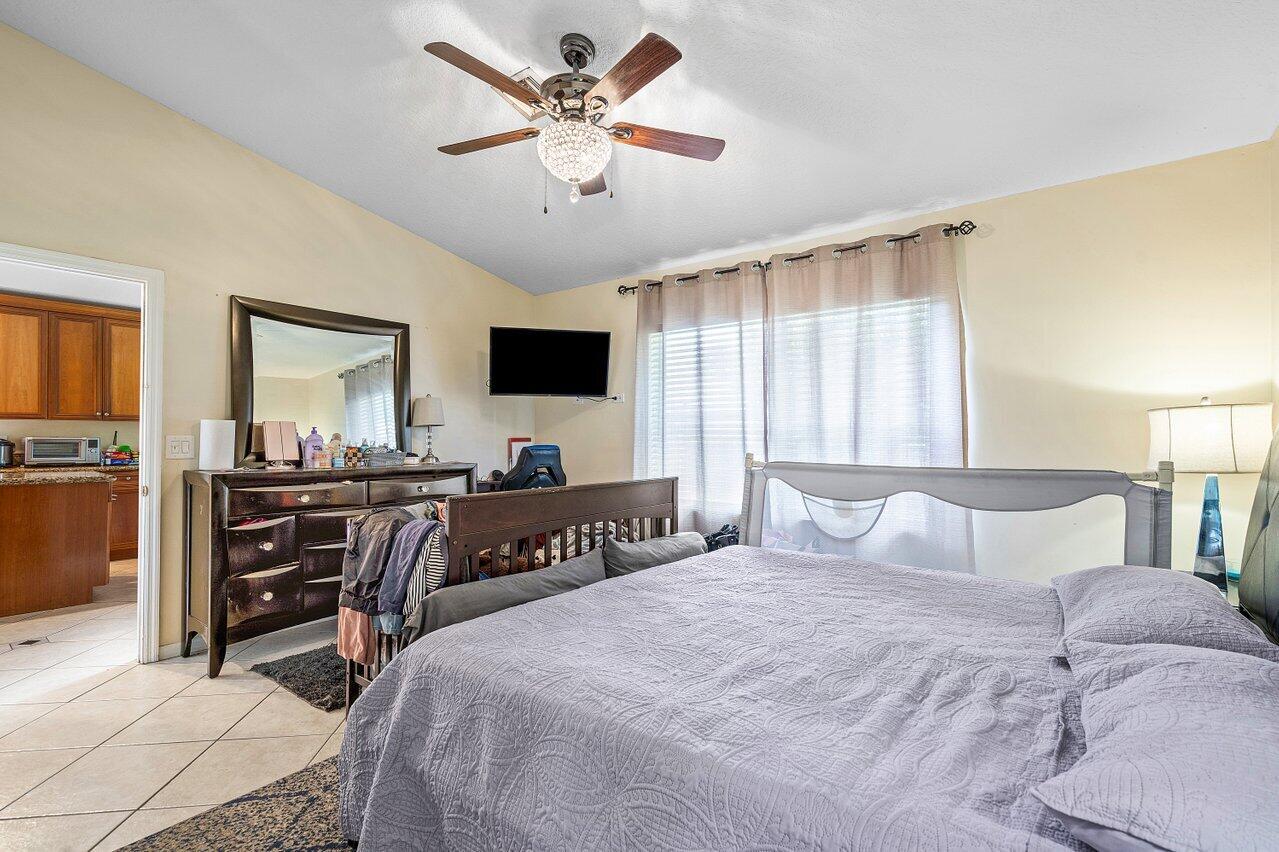 177 Heming Way Boynton Beach, FL 33426 - Photo 17 of 22 a bedroom with a bed and a flat screen tv