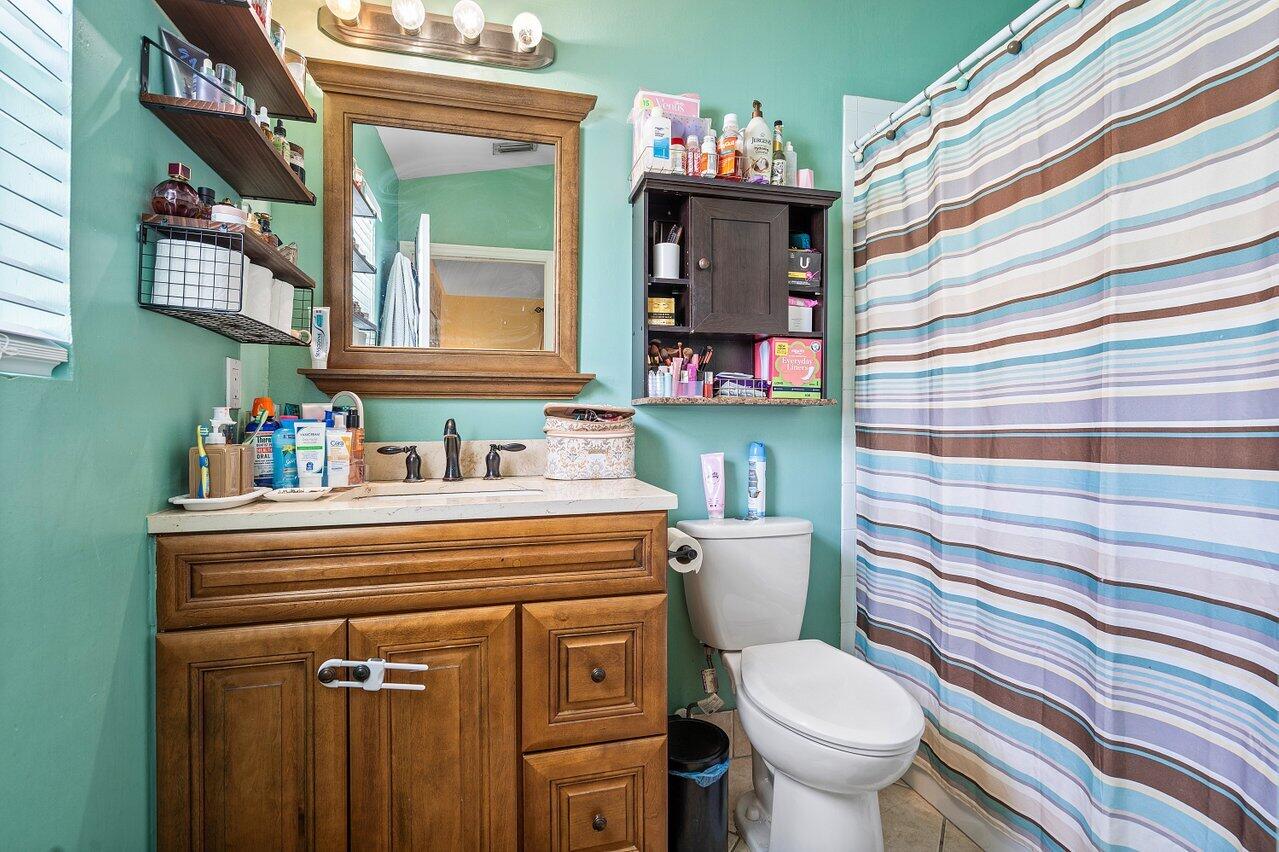177 Heming Way Boynton Beach, FL 33426 - Photo 18 of 22 a bathroom with a sink toilet and mirror