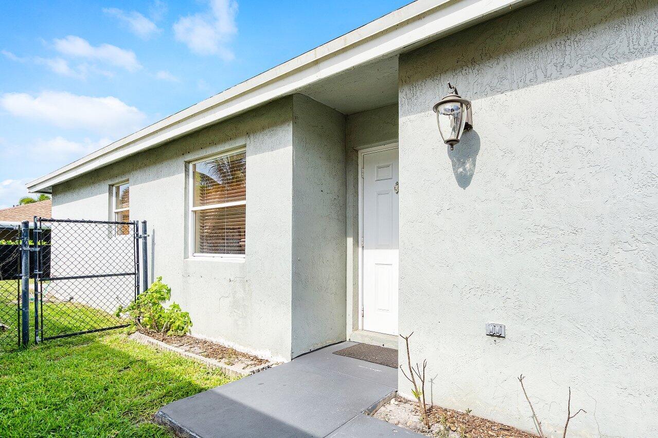 177 Heming Way Boynton Beach, FL 33426 - Photo 3 of 22 a view of a small house with a yard