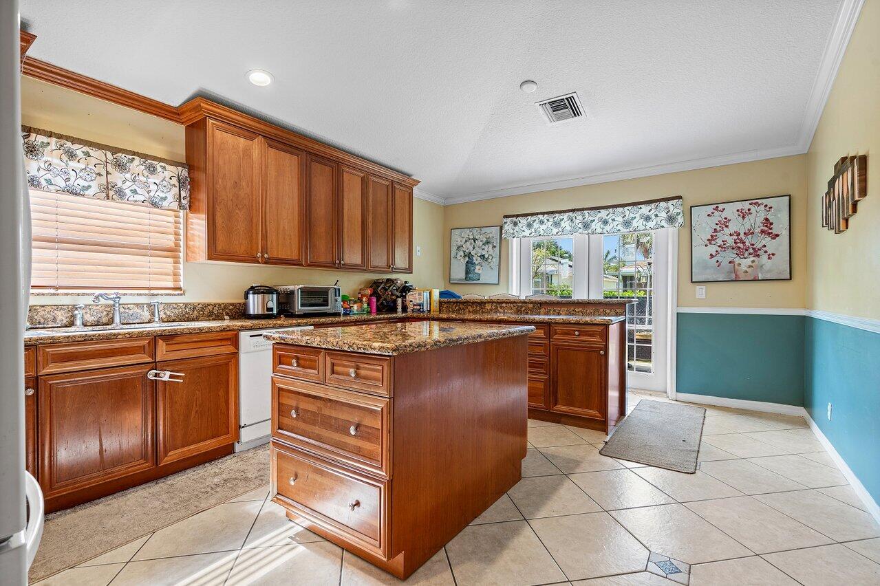 177 Heming Way Boynton Beach, FL 33426 - Photo 6 of 22 a kitchen with stainless steel appliances granite countertop a stove a sink and a refrigerator