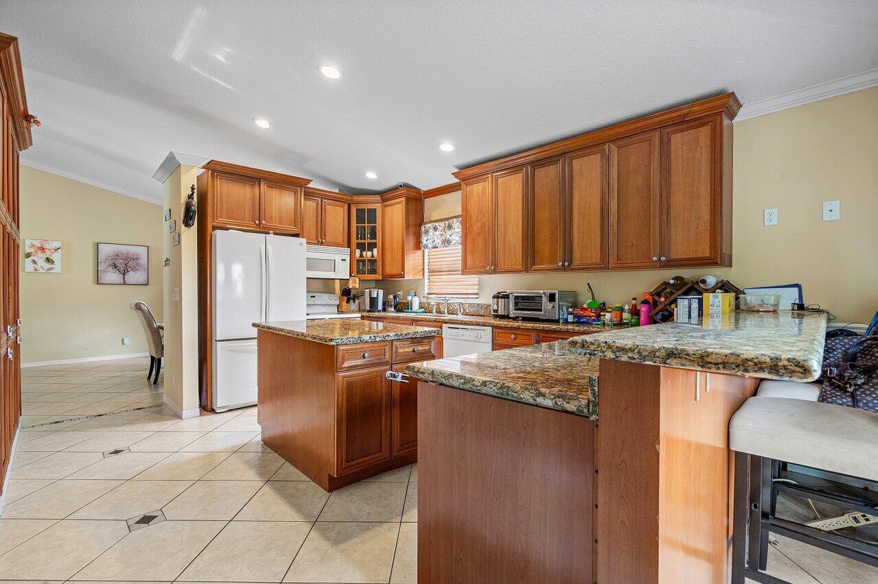 177 Heming Way Boynton Beach, FL 33426 - Photo 7 of 22 a kitchen with stainless steel appliances granite countertop a refrigerator a stove and a sink