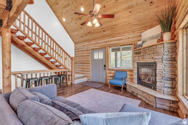 2348 North Miles Holw Road, Unit 26 Kamas, UT 84036 - Photo 7 of 31 Living room featuring hardwood / wood-style floors, a vaulted wooden ceiling, a stone fireplace, log walls, and ceiling fan