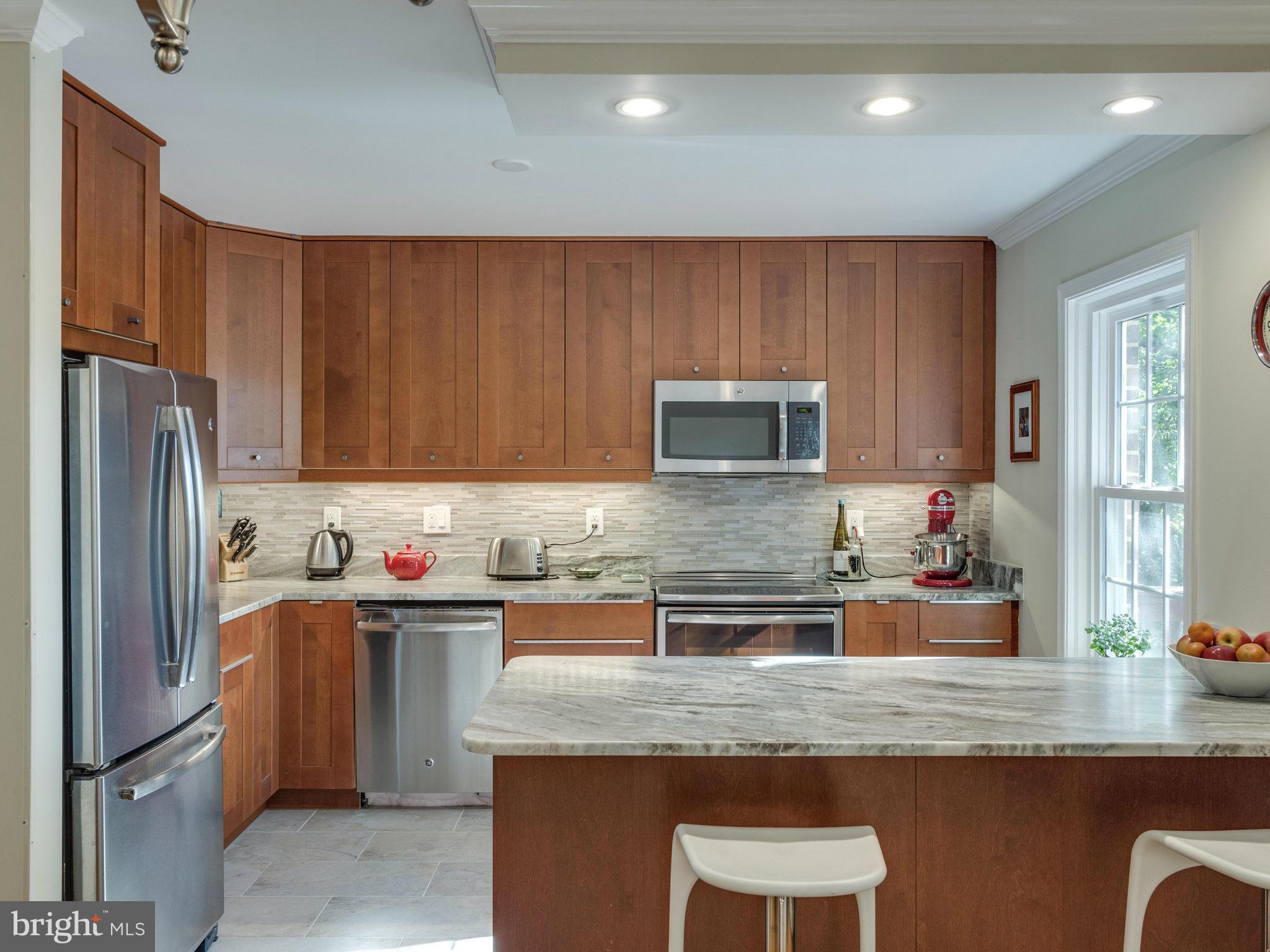 2071 South Glebe Road Arlington, VA 22206 - Photo 5 of 19 a kitchen with granite countertop stainless steel appliances a sink refrigerator and microwave