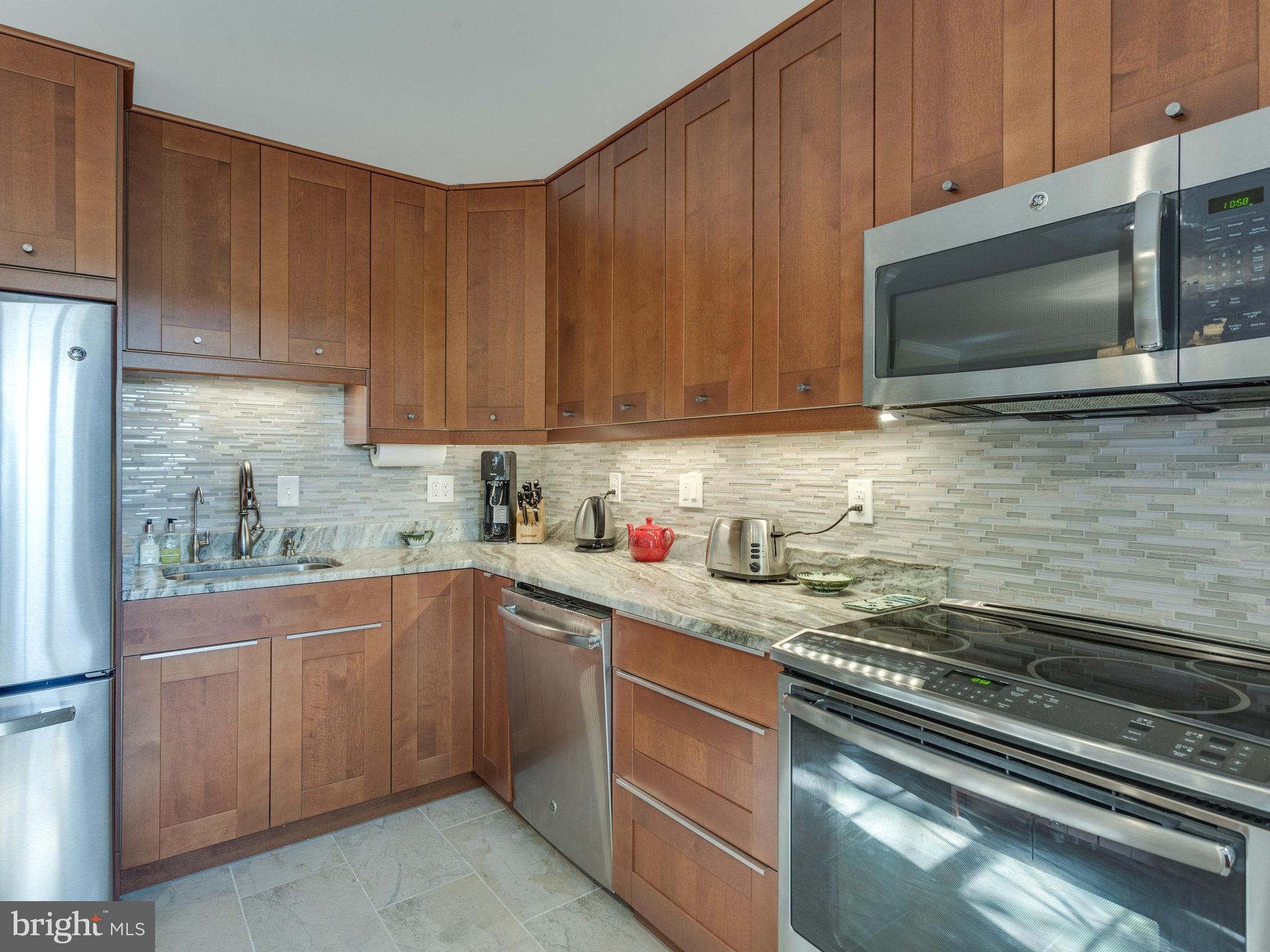 2071 South Glebe Road Arlington, VA 22206 - Photo 7 of 19 a kitchen with stainless steel appliances granite countertop a sink stove and microwave