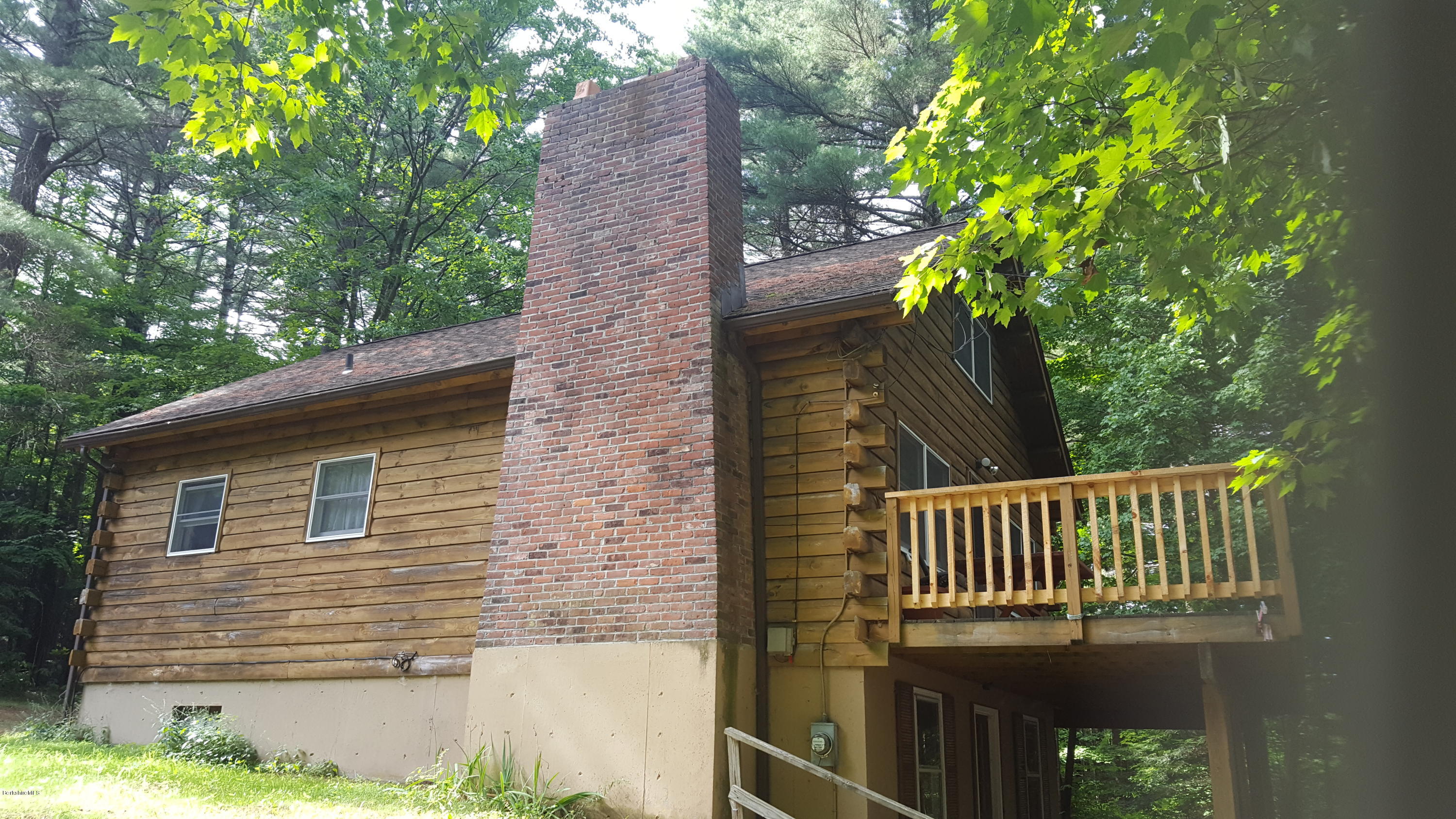 514 South Main Road Otis, MA 01253 - Photo 2 of 21 a view of a brick house with a small yard and wooden fence