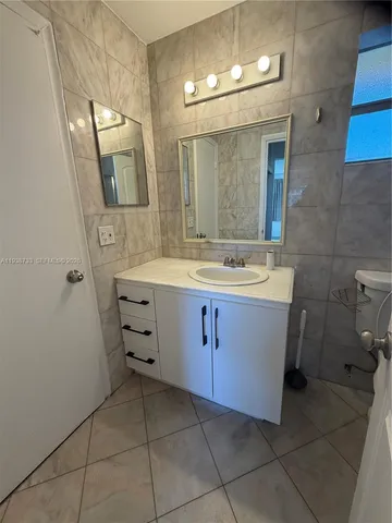 a bathroom with a sink vanity and mirror