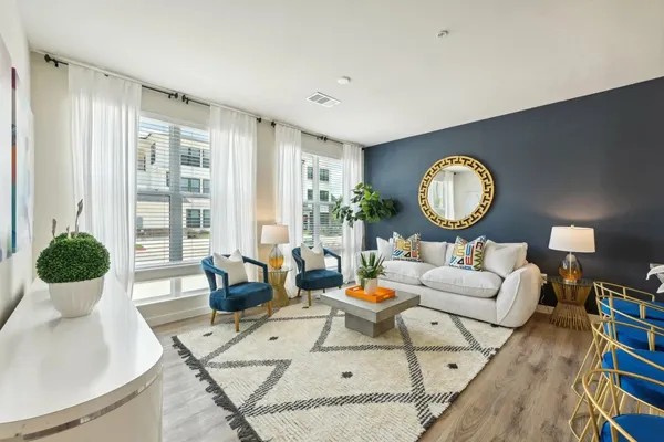 a living room with furniture chandelier and a large window