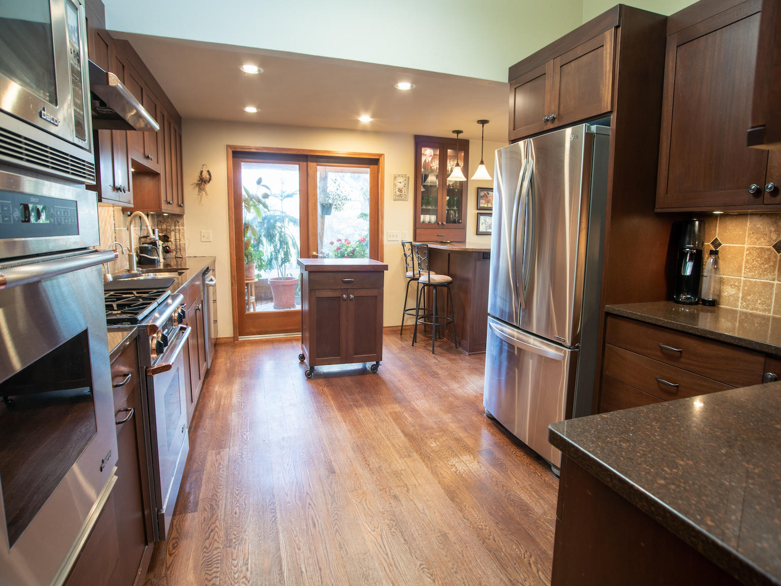 64295 Schibel Road Bend, OR 97703 - Photo 7 of 41 a kitchen with stainless steel appliances granite countertop a refrigerator stove oven and wooden floor