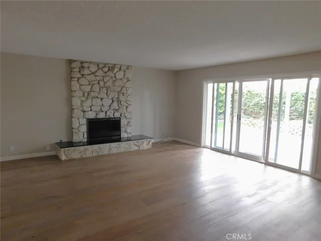 a view of an empty room with a fireplace and a window